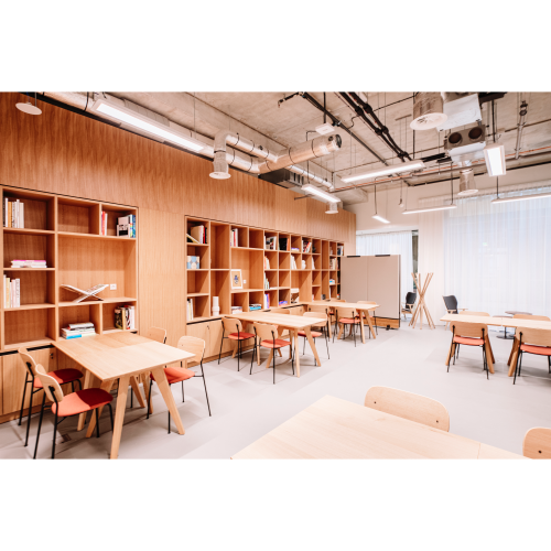 Bright, furnished office space with wooden tables and shelves located at Hoogstraat 185, Rotterdam Center, ideal for office space rental.