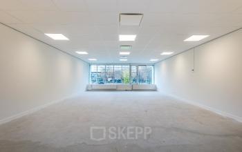 Spacious office to rent at Weena 87, Rotterdam Center featuring bright natural light through large windows and minimalist design, ideal for customization.
