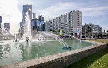 Street view of Weena 87 in Rotterdam Center, showcasing a modern cityscape with nearby office buildings and a fountain, ideal for office space rental.