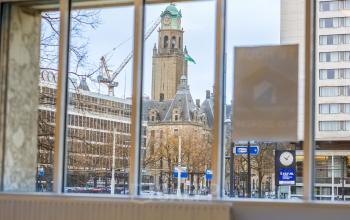View from an office space rental in Weena 87, Rotterdam Center, showcasing iconic city landmarks through large windows, creating an inspiring urban atmosphere.