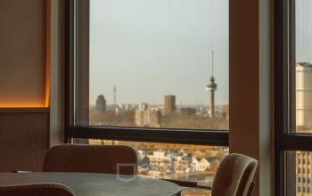 Furnished office space at Coolsingel 139, Rotterdam Center, featuring large windows with a city view, ideal for rent office space with functional work areas.