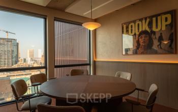 Cozy conference room at Coolsingel 139, Rotterdam Center with a large round table and city views, ideal for office space rental.