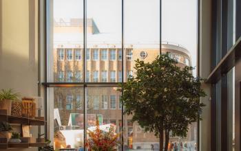 Spacious modern office area with high ceilings and large windows overlooking Rotterdam Center, featuring comfortable seating and abundant natural light for an inviting office space rental.