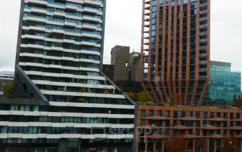 Exterior view of modern office buildings at Wijnhaven 76, Rotterdam Center, ideal for office space rental with water view.