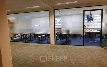 Interior view of an office space available for rent at Wijnhaven 76 in Rotterdam Center, featuring modern workspaces with desks and chairs.