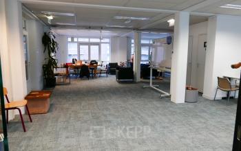 Spacious open floor plan of an office available for rent at Wijnhaven 76 in Rotterdam Center, featuring desks, chairs, and a whiteboard, ideal for collaborative work and meetings.