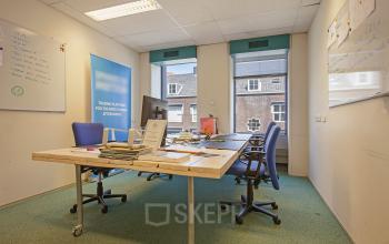 Spacious office space rental at Westblaak 92 in Rotterdam Center with a large desk, chairs, and whiteboards.