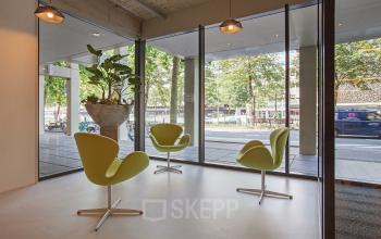 Modern office space rental at Westblaak 92, Rotterdam Center, with stylish chairs, potted plants, and large windows.