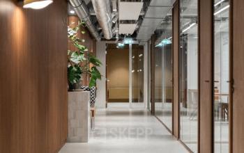 Modern corridor in an office space for rent at Stadhuisplein 9-23, featuring stylish wooden paneling and visible ceiling ductwork.