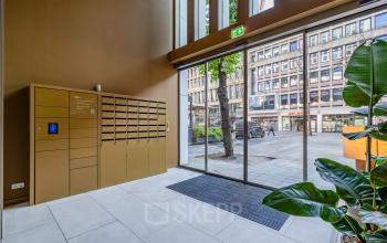 Bright entrance area with large glass doors at office space rental location Stadhuisplein 9-23, Rotterdam Center.