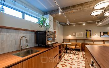 Furnished office space with a wooden counter, tiles, and a coffee station at Stadhuisplein 9-23, ideal for rent office space in Rotterdam Center.