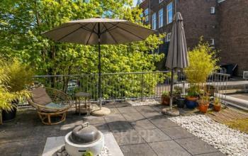 Outdoor terrace at Office Space Rental, Mauritsweg 33 A01 in Rotterdam Center, featuring seating, parasols, and greenery.