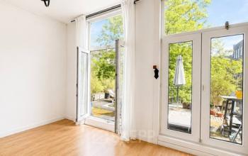 Bright office space at Mauritsweg 33 A01 in Rotterdam Center, featuring large windows and hardwood flooring, available for office space rental.