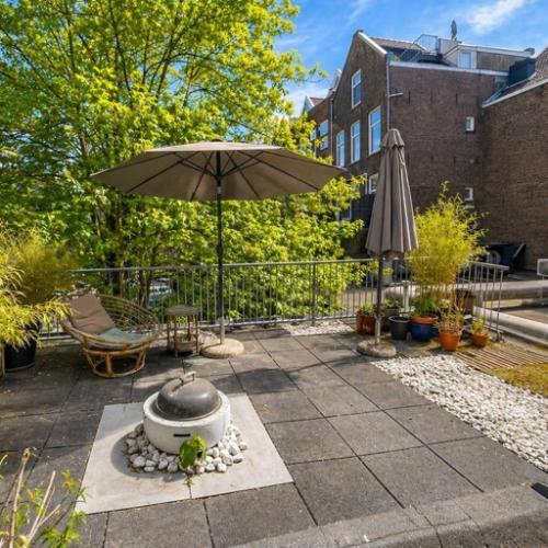 Outdoor terrace at Office Space Rental, Mauritsweg 33 A01 in Rotterdam Center, featuring seating, parasols, and greenery.