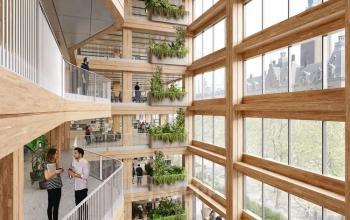 Bright and modern atrium at Coolsingel 75, Rotterdam Center, showcasing multiple floors of office space rental. People are engaged in conversation at balconies, surrounded by greenery and natural light.
