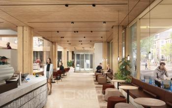 Contemporary office entrance with a relaxed seating area and people working and collaborating at Coolsingel 75, ideal for office space rental in Rotterdam Center.