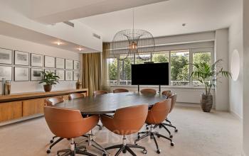 Modern conference room at Coolsingel 104, Rotterdam Center with large table, leather chairs, and natural light.