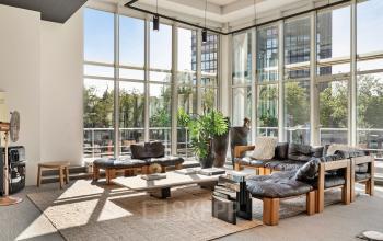 Bright office space at Coolsingel 104 in Rotterdam Center with large windows, modern furniture, and a cozy seating area ideal for meetings. Ideal for office space rental.