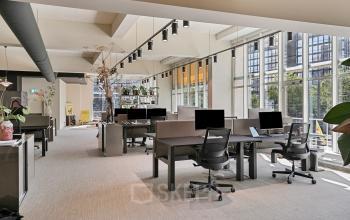 Spacious office at Coolsingel 104 in Rotterdam Center features furnished workstations under modern lighting, ideal for rent office space. Large windows allow plenty of natural light.