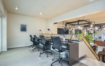 Modern, well-lit office space at Coolsingel 104 in Rotterdam Center, featuring a stylish desk area with chairs and lamps, perfect for rent office space opportunities.