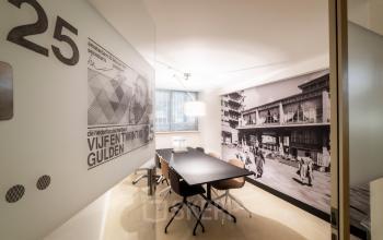 Modern meeting room at Coolsingel 104, Rotterdam Center with a mural and minimalistic design, offering office space rental.