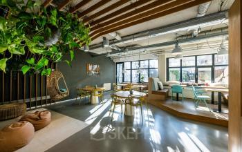 Bright office space in Rotterdam Center featuring modern decor, natural light, and seating areas, ideal for office space rental.