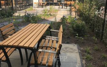 Outdoor seating area at Westblaak 180, Rotterdam Center, ideal for office space rental. Featuring wooden benches and greenery, it's a perfect spot to take a break.