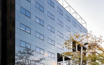 Exterior view of the office building at Westblaak 180 in Rotterdam Center, with glass facade and street view.