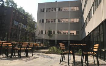 Outdoor area at Westblaak 180, Rotterdam Center, featuring chairs and tables for casual meetings or breaks. Ideal spot for office space rental with fresh air.