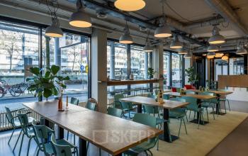 Modern office space at Westblaak 180, Rotterdam Center, featuring large windows, contemporary furniture, and an inviting atmosphere for meetings or work sessions. Ideal for those seeking office space rental.