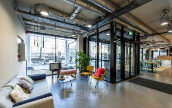 Stylish office lobby at Westblaak 180, Rotterdam Center, with bright seating, large windows, and industrial design, perfect for office space rental.