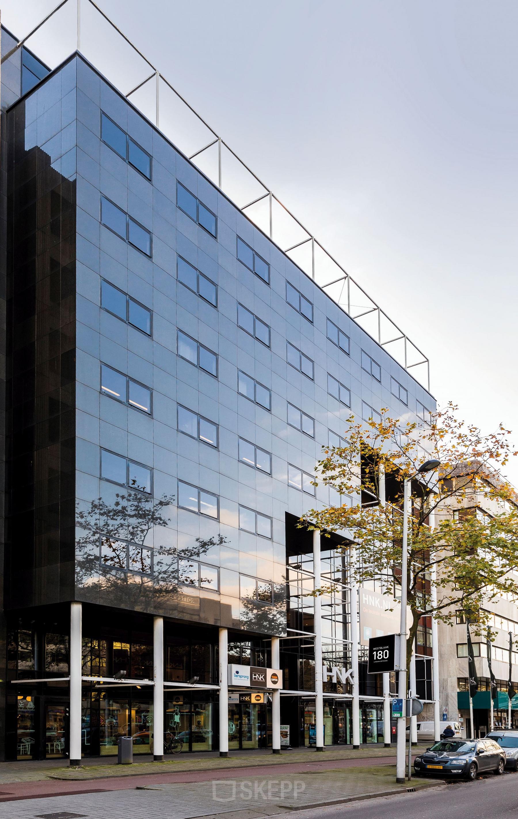 Exterior view of the office building at Westblaak 180 in Rotterdam Center, with glass facade and street view.