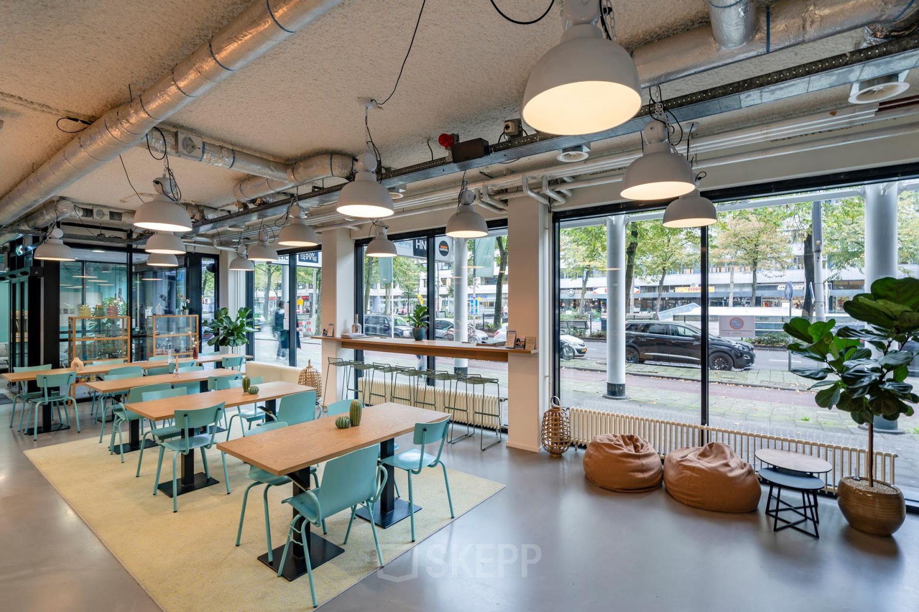 Interior workspace at Westblaak 180, Rotterdam Center with modern furnishings, large windows, and ample seating. Office space rental available.
