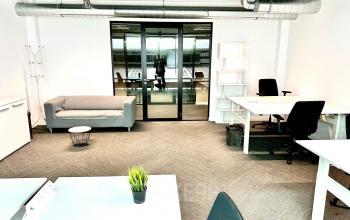 Office space for rent at Beursplein 37, Rotterdam Center, featuring work desks, chairs, a sofa, and modern decor.