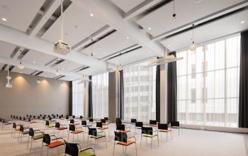 Spacious and bright conference room with rows of chairs, large windows, and modern lighting at Beursplein 37, Rotterdam Center, ideal for office space rental.