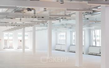 Modern, open-floor office space with large windows and white pillars at Beursplein 37, Rotterdam Center, available for office space rental.