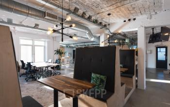 Spacious, modern office to rent at Schiedamse Vest 154 in Rotterdam Center, featuring stylish booths, large windows, and a collaborative workspace area with ample natural lighting.