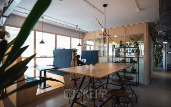 Modern furnished office space with a communal table, lounge seating, and natural lighting at Schiedamse Vest 154, Rotterdam Center. Ideal for office space rental.