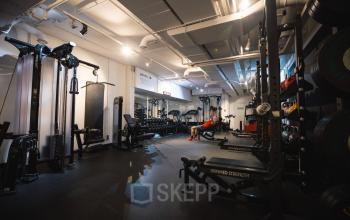 Modern gym located in office building at Schiedamse Vest 154, Rotterdam Center, equipped with various workout machines and weights.
