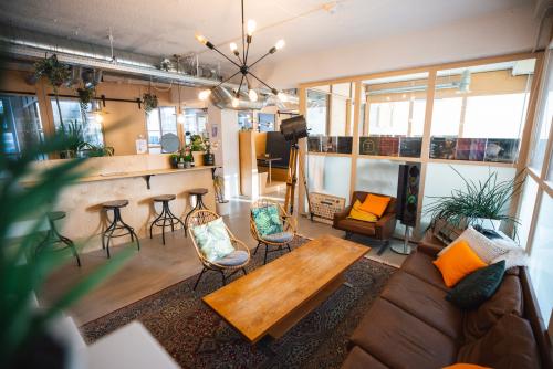 Bright and inviting lounge area with comfortable seating, wooden furniture, and a bar counter in the office space at Schiedamse Vest 154, Rotterdam Center.
