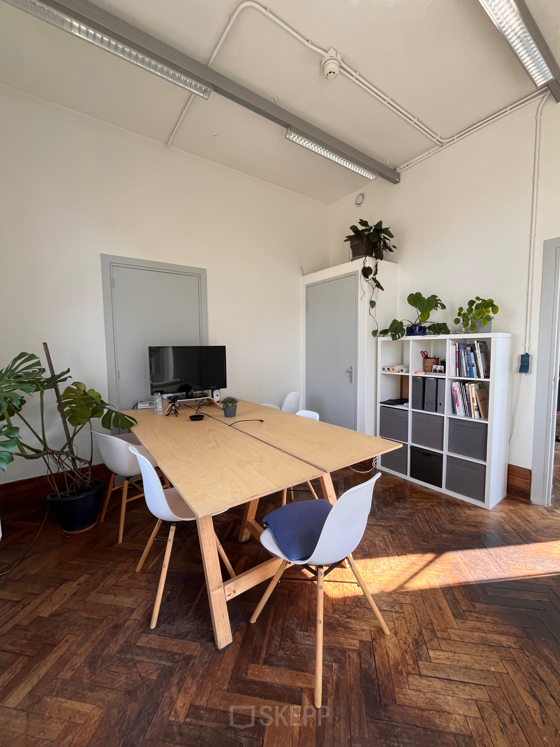 Bright office space at Willem Buytewechstraat 45, Rotterdam Delfshaven with a large wooden table, chairs, and plants.