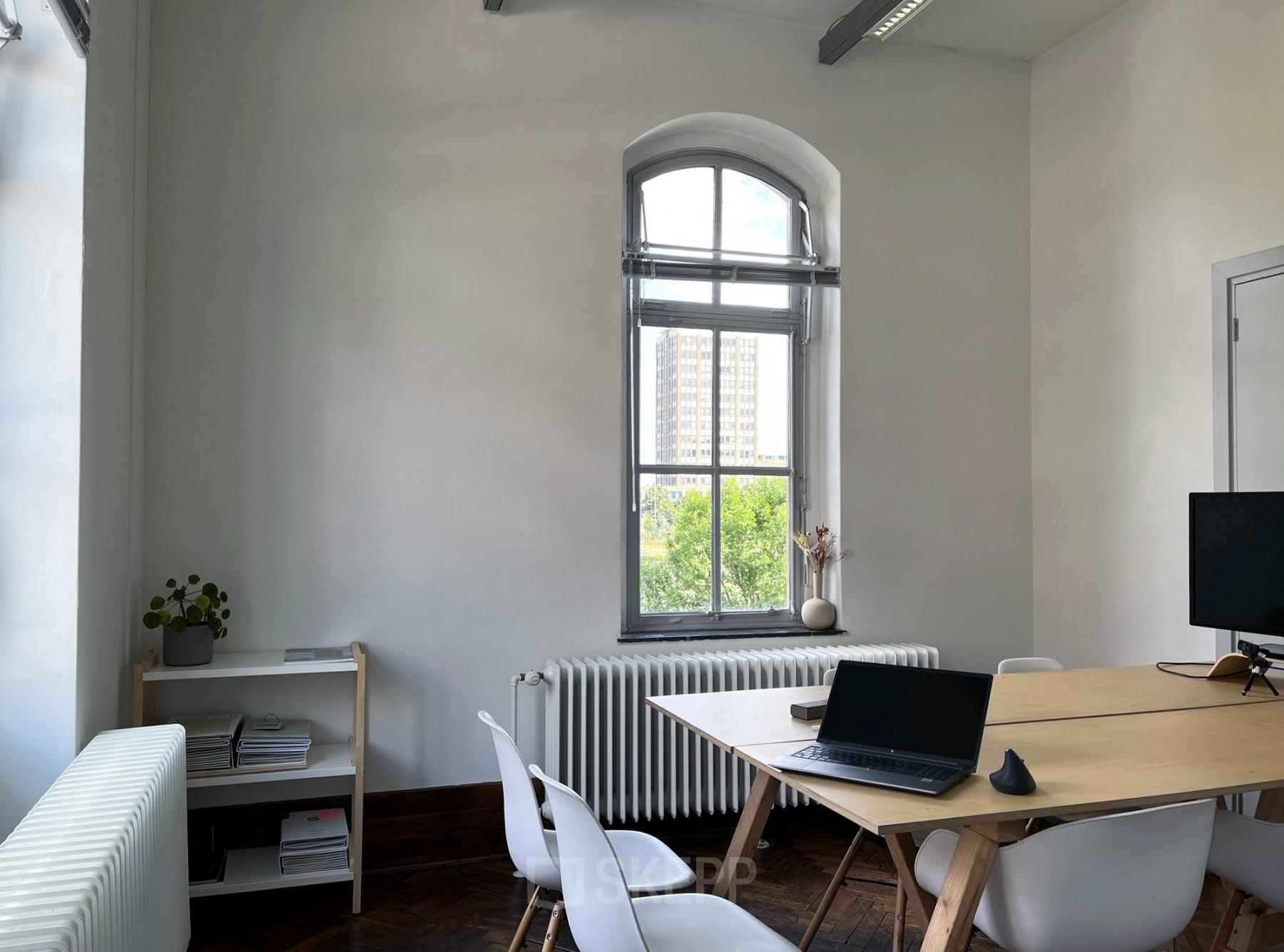 Bright office space with wooden furniture and large window at Willem Buytewechstraat 45 in Rotterdam Delfshaven, perfect for office space rental.