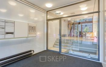 Entrance area at Lloydstraat 21 B in Rotterdam Delfshaven, an inviting space ideal for office space rental with a modern design and glass doors.