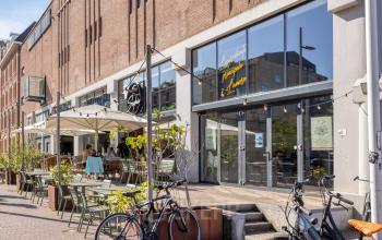 Exterior view of Lloydstraat 21 B in Rotterdam Delfshaven with tables and chairs outside, suitable for an office to rent.