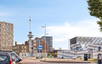 Exterior view of Lloydstraat 21 B in Rotterdam Delfshaven, featuring nearby buildings and a glimpse of urban architecture.