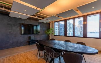 Bright conference room at Kratonkade 7 - 27, Rotterdam Delfshaven with modern furnishings and large windows. Ideal for office space rental.