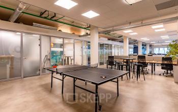 Interior view of a furnished office space featuring a ping pong table and desks at Kratonkade 7-27, Rotterdam Delfshaven, ideal for office space rental.
