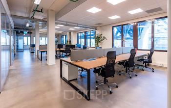 Contemporary office space at Kratonkade 7 - 27 in Rotterdam Delfshaven, featuring rows of modern desks and chairs. Ideal for rent office space needs in an open floorplan design.