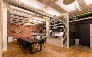 Spacious office to rent at Kratonkade 7 - 27, Rotterdam Delfshaven, featuring a large communal table and modern kitchenette for office space rental.