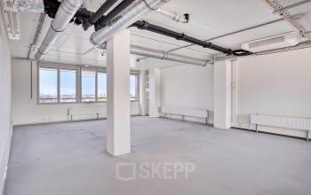 Interior view of an unfurnished office space at Kratonkade 7 - 27, Rotterdam Delfshaven, ideal for office space rental with large windows offering natural light.